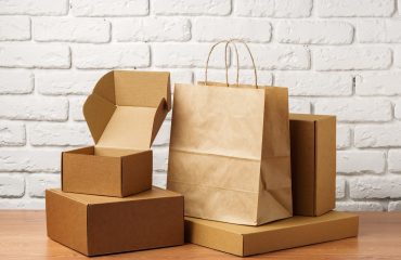 Stacked Cardboard Boxes Against A White Brick Wall close up
