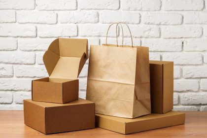 Stacked Cardboard Boxes Against A White Brick Wall close up